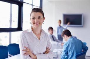 business woman with her staff in background at office photo