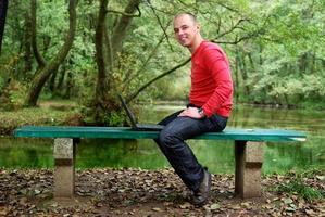 young businessman in red shirt working on laptop photo