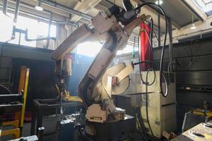 Turkey, 2022 - Automatic welding robot mechanical arm is working in the modern automobile parts factory. photo