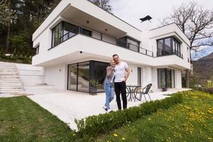 pareja abrazándose frente a una nueva casa de lujo foto