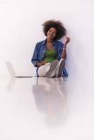 african american woman sitting on floor with laptop photo