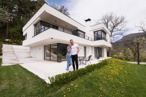 couple hugging in front of  new luxury home photo