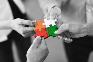 Group of business people assembling jigsaw puzzle photo