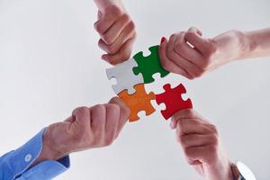 Group of business people assembling jigsaw puzzle photo