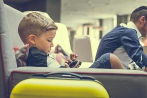 Small boy playing video games in hotel lobby. photo