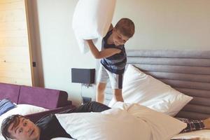 Small boy having fun while pillow fighting with his father. photo
