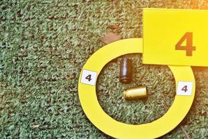 Pistol's bullet shells and yellow number paper sign on floor, concept for keeping physical evidences of the use of pistols, guns and bullet shells at the point of the murder. photo