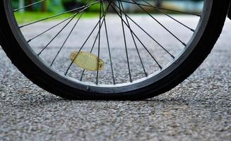 cierre la rueda trasera plana de la bicicleta que estacionó en el pavimento, enfoque suave y selectivo. foto