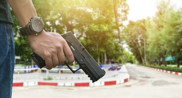 9mm automatic pistol holding in right hand of shooter, concept for security, robbery, gangster, bodyguard around the world. selective focus on pistol. photo