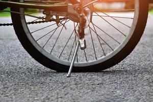 Closeup flat rear wheel of the bike which parked on pavement, soft and selective focus. photo