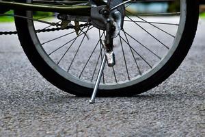 cierre la rueda trasera plana de la bicicleta que estacionó en el pavimento, enfoque suave y selectivo. foto