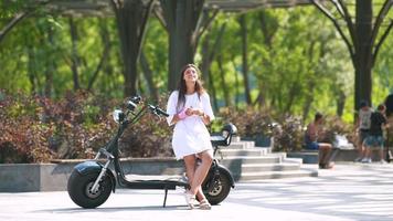 une jeune femme fait du scooter électrique par une journée ensoleillée video