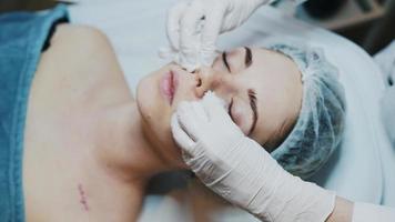 dermatologista aplicando produto facial na mulher video
