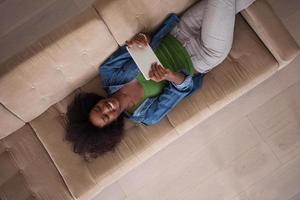 mujer afroamericana en casa con vista superior de tableta digital foto