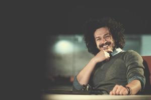 man working on computer in dark startup office photo