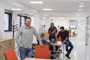 startup business, businessman portrait at modern office, team brainstorming in background photo