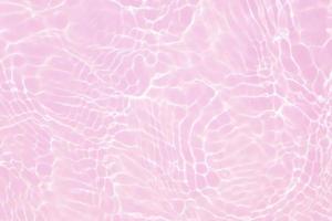 Defocus blurred transparent pink colored clear calm water surface texture with splash, bubble. Shining pink water ripple background. Surface of water in swimming pool. Tropical pink water color flow. photo