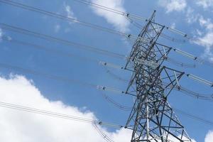 torre de transmisión de electricidad contra el cielo azul. poste de electricidad de alto voltaje. foto