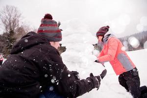 grupo de jóvenes haciendo un muñeco de nieve foto