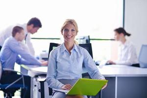 business woman with her staff in background at office photo