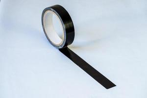 Rollo de cinta adhesiva negra aislado sobre fondo blanco. foto