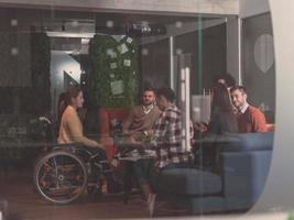 Businesswoman in wheelchair having business meeting with team at modern office photo