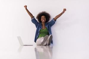 mujer afroamericana sentada en el suelo con una laptop foto