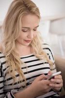 woman sitting on sofa with mobile phone photo