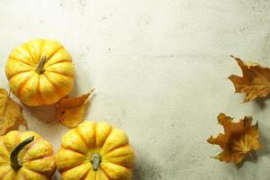 borde de esquina otoñal de calabazas naranjas y blancas. borde de esquina de otoño con calabazas naranjas heladas sobre un fondo de pancarta de madera blanca rústica. vista aérea con espacio de copia. foto