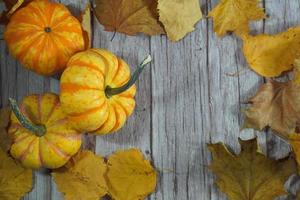 borde de esquina otoñal de calabazas naranjas y blancas. borde de esquina de otoño con calabazas naranjas heladas sobre un fondo de pancarta de madera blanca rústica. vista aérea con espacio de copia. foto