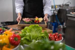 female Chef holding beef steak plate photo