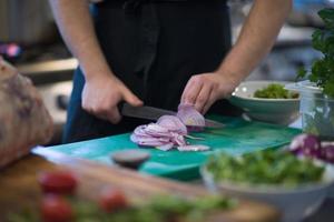 Chef  hands cutting the onion with knife photo