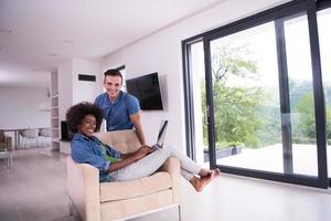 multiethnic couple on an armchair with a laptop photo