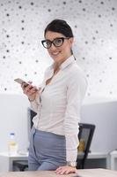 Elegant Woman Using Mobile Phone in startup office building photo