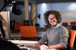 man working on computer in dark startup office photo