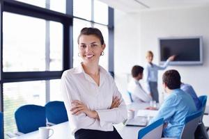 business woman with her staff in background at office photo