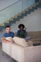 multiethnic couple relaxing at  home with tablet computers photo