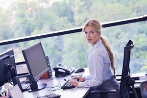 mujer de negocios trabajando en su escritorio en una oficina foto