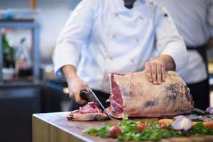 chef cortando un gran trozo de carne foto