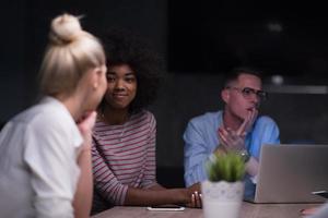 Multiethnic startup business team in night office photo