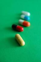 pills on green background in row photo