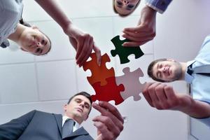 Group of business people assembling jigsaw puzzle photo