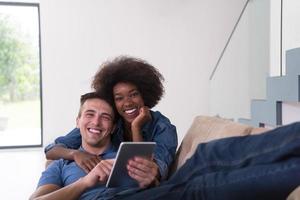 multiethnic couple relaxing at  home with tablet computers photo