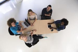 equipo de negocios multiétnico de inicio en la vista superior de la reunión foto