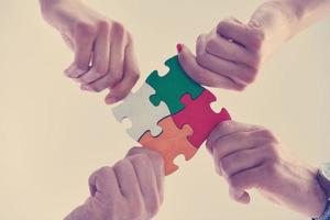 Group of business people assembling jigsaw puzzle photo