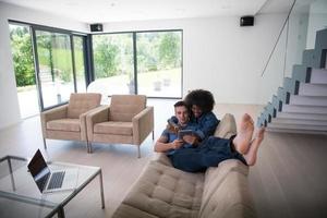 young multiethnic couple relaxes in the living room photo