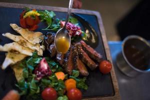 Chef hand finishing steak meat plate photo