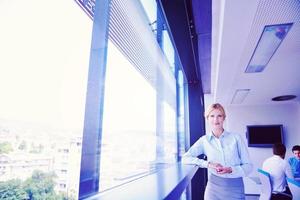 business woman with her staff in background at office photo