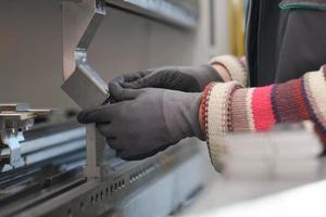 mujer que trabaja en una fábrica moderna y prepara material para una máquina cnc. foto