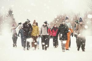 grupo de jóvenes caminando por un hermoso paisaje invernal foto